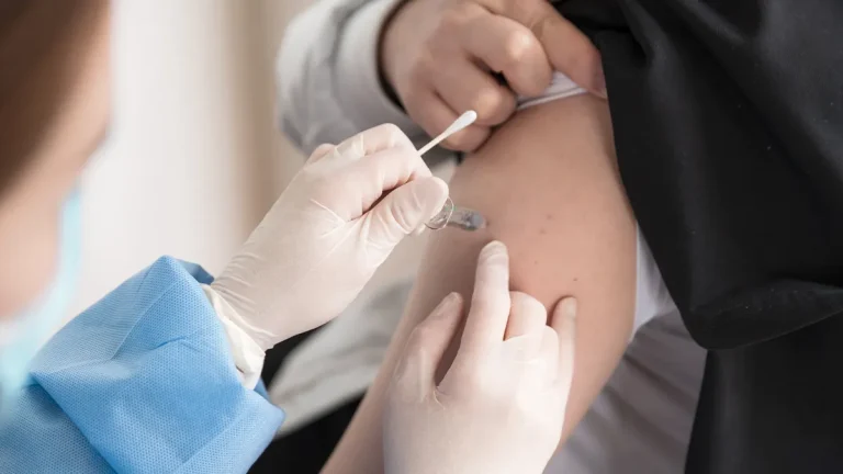 Healthcare worker administering a vaccine, illustrating Joe Bresee’s op-ed on vaccination and public health systems